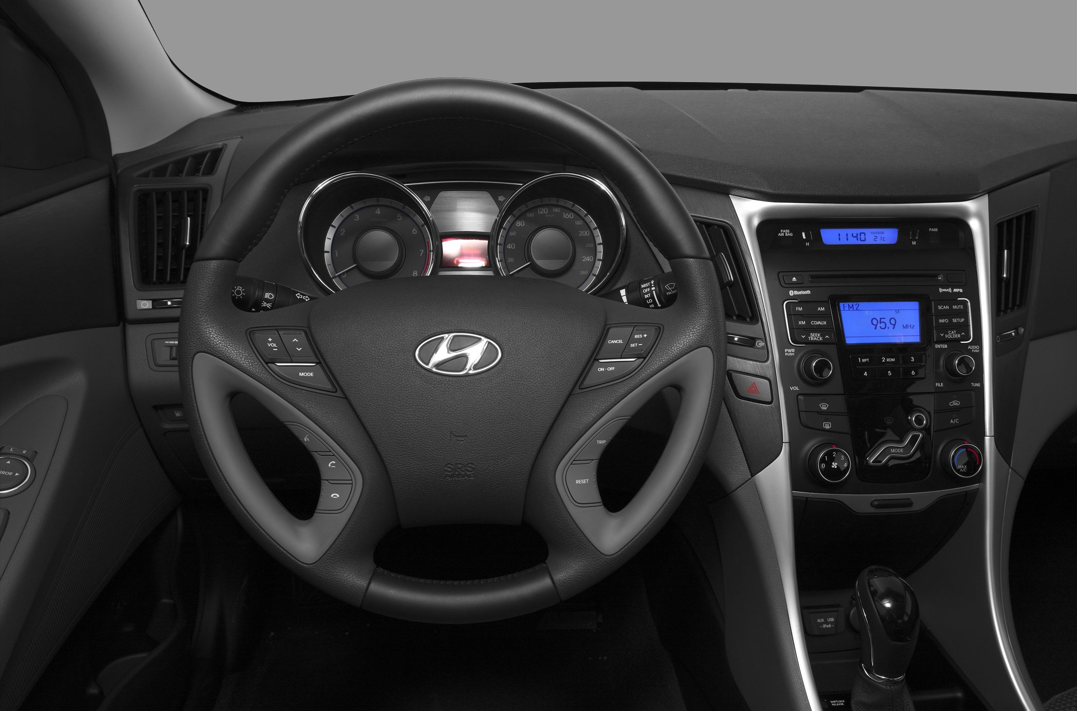 Steering wheel with controls and dashboard featuring audio & climate panels