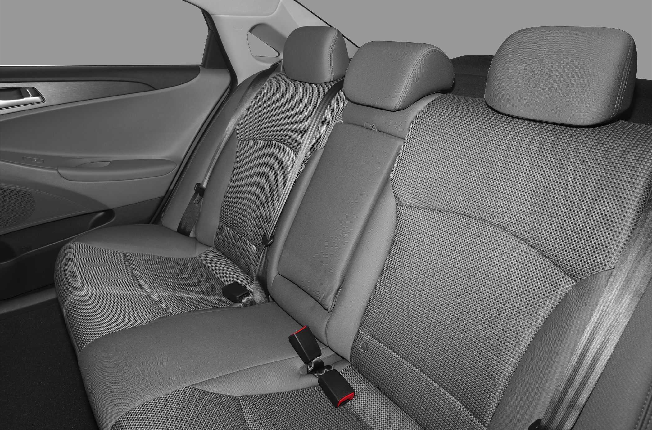 Rear seat upholstery and seat belts in a sedan interior