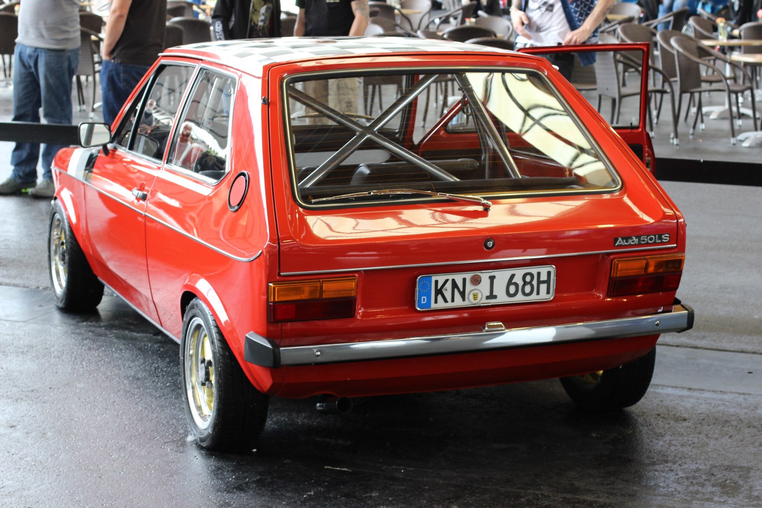 Red compact hatchback with visible internal racing roll cage