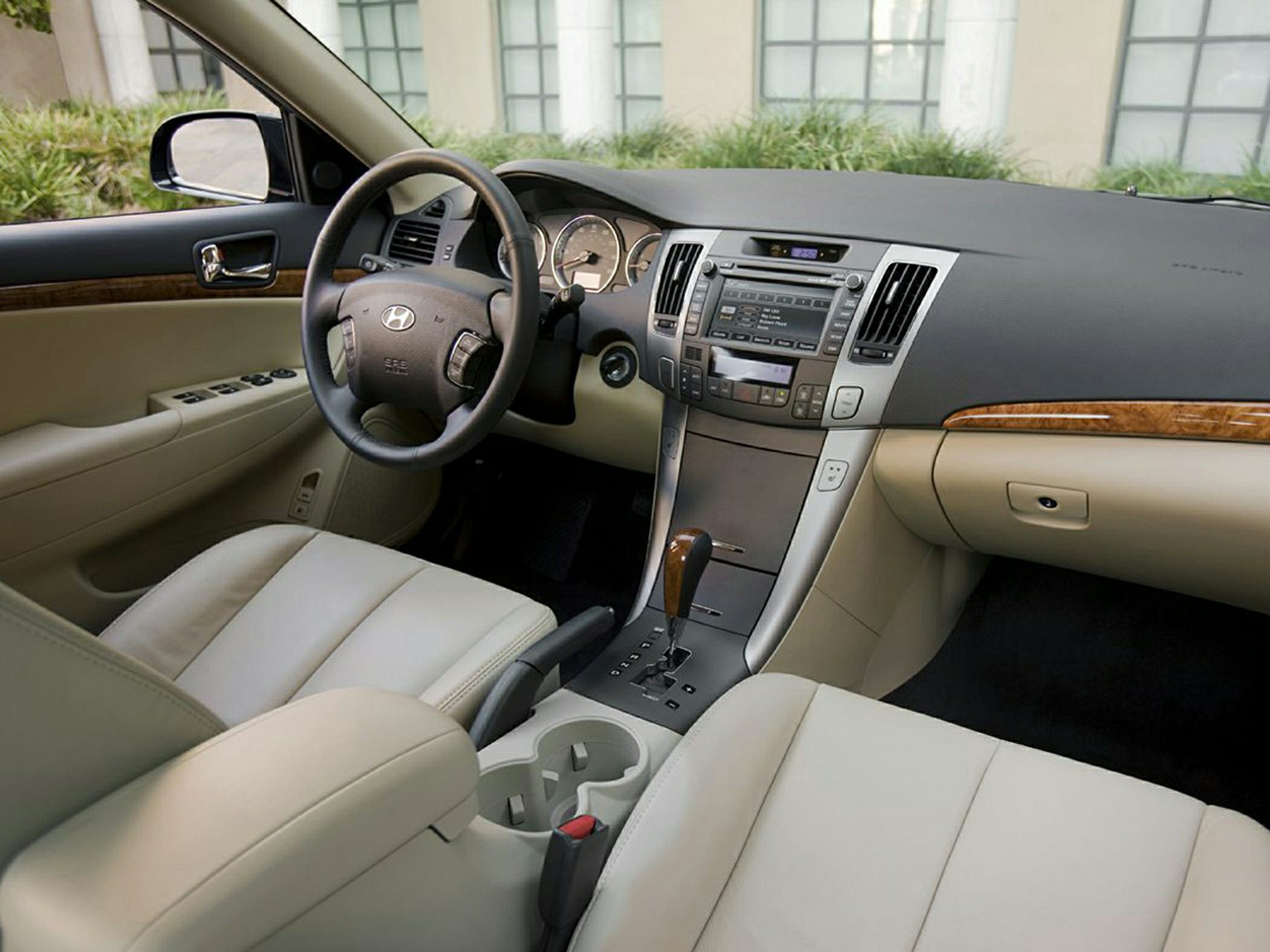 Dashboard, steering wheel, and beige leather seats inside a car