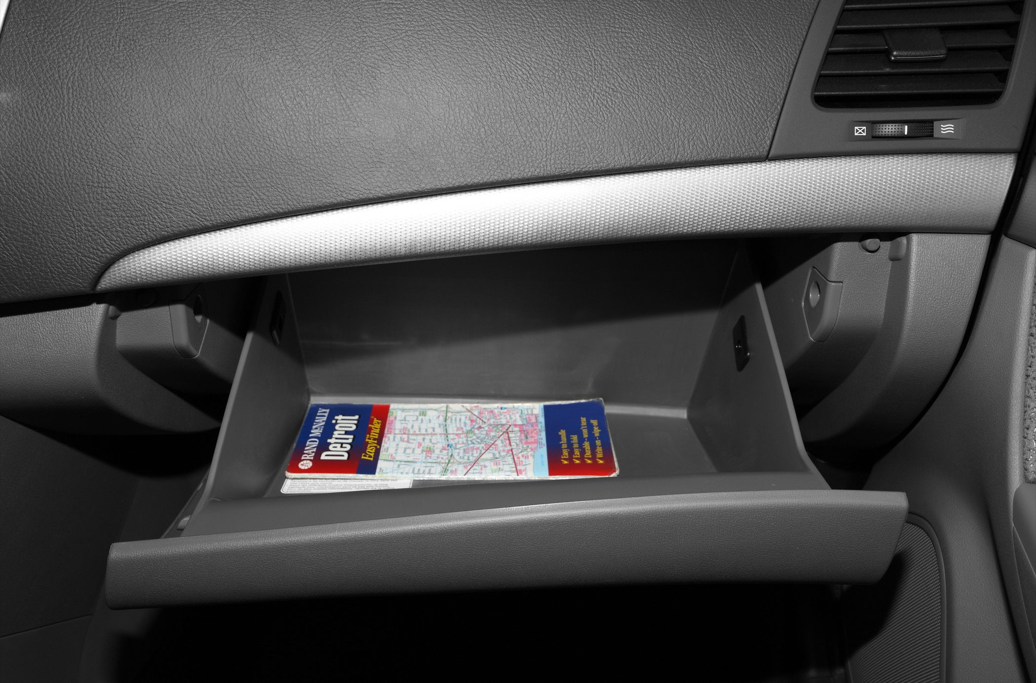 Open glovebox with a map inside in a vehicle's interior