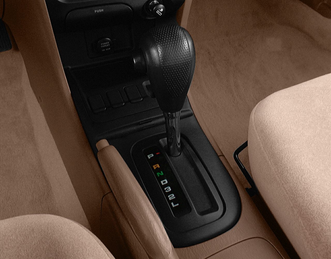 Automatic gear shift and handbrake in tan car interior