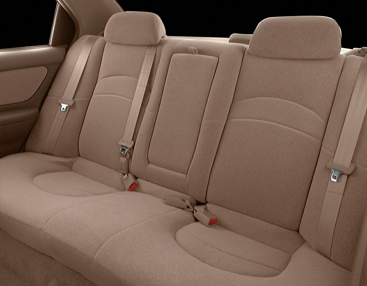 Beige rear seat interior with headrests and seat belts