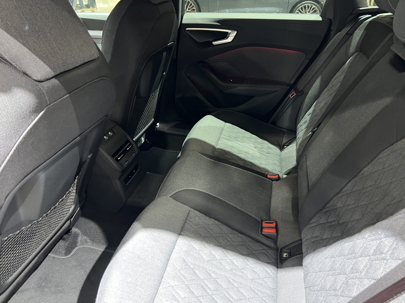 Quilted fabric rear seats with air vents and door panel close-up