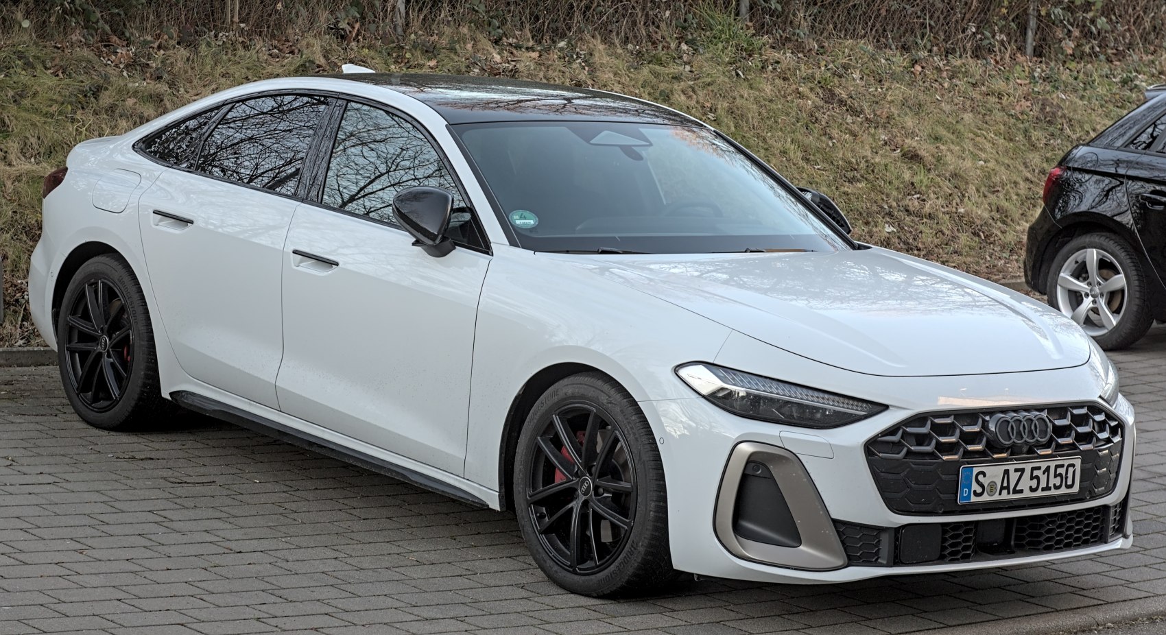 Honeycomb grille and sharp LED headlights on a sleek white sedan