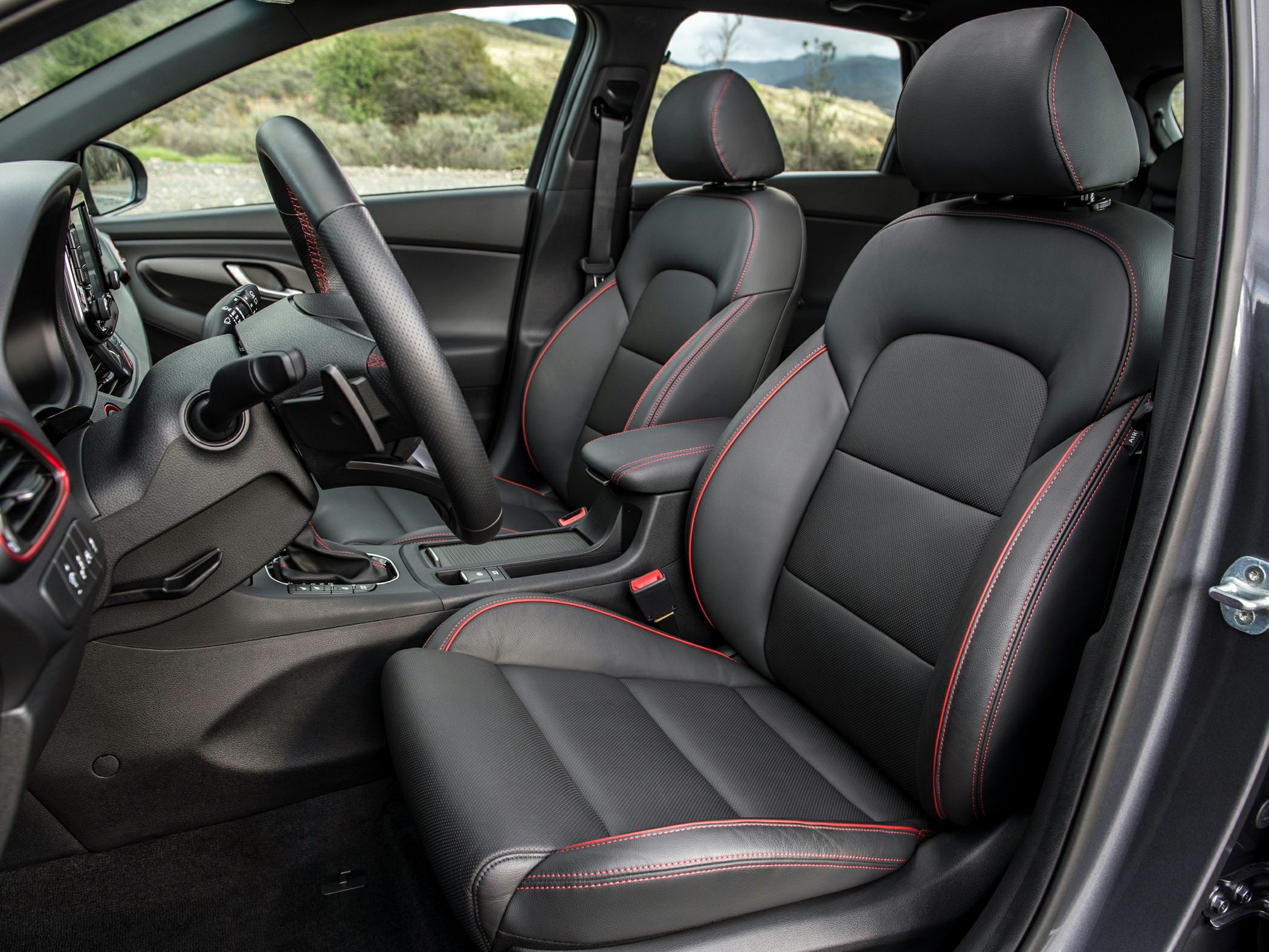 Black leather front seats with red stitching and sporty contours.