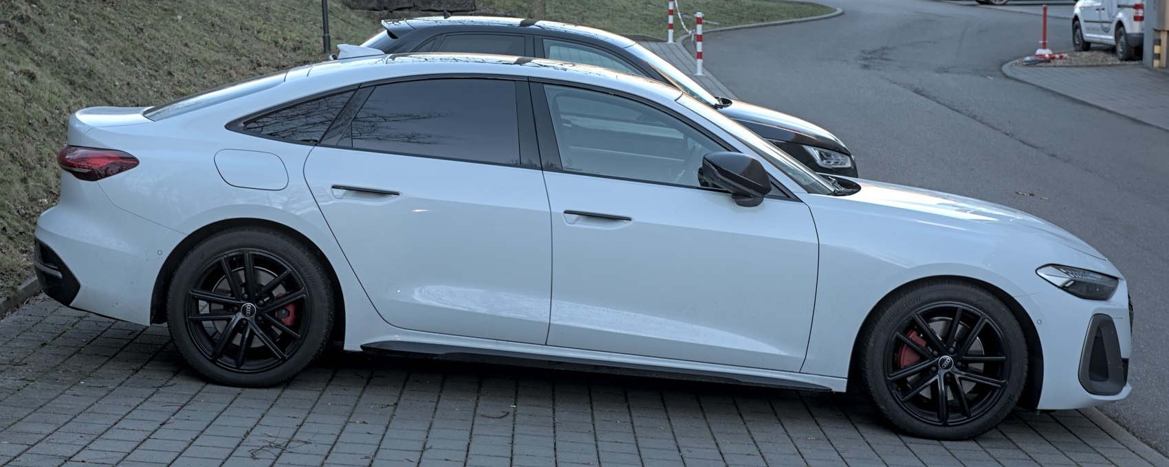 Side view of a sporty sedan with black alloy wheels and tinted windows