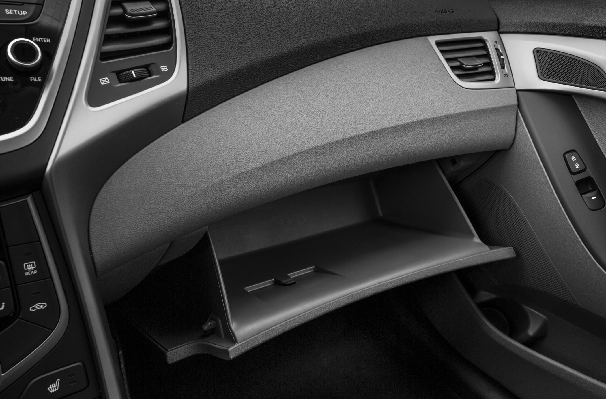 Open glove compartment with dashboard and side door controls.