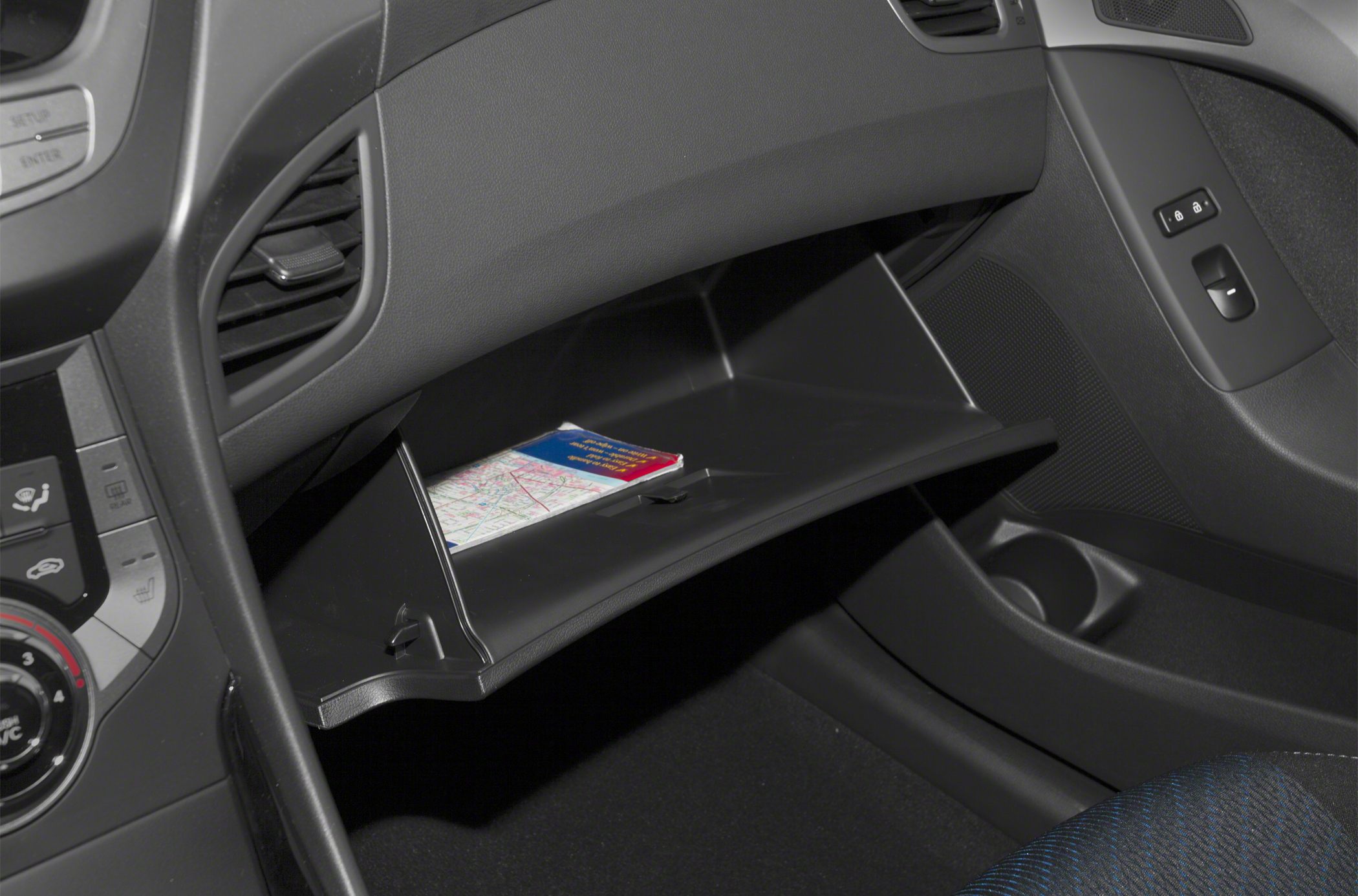 Open glove compartment with map inside on car passenger side