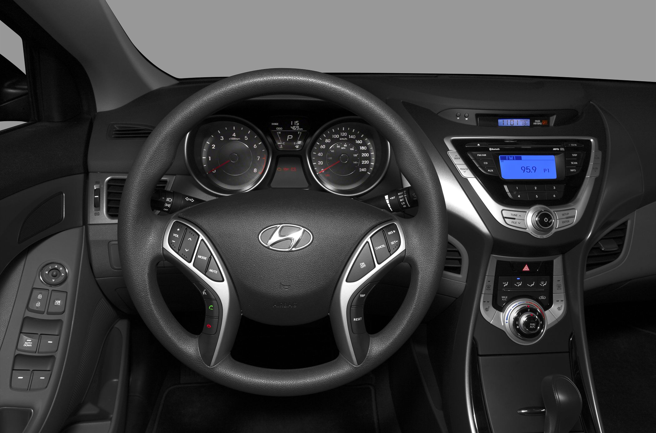 Steering wheel with control buttons and dashboard featuring radio and climate controls