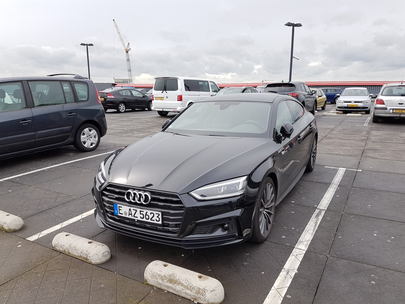 Black luxury sedan with LED headlights and sleek grille, angled front view