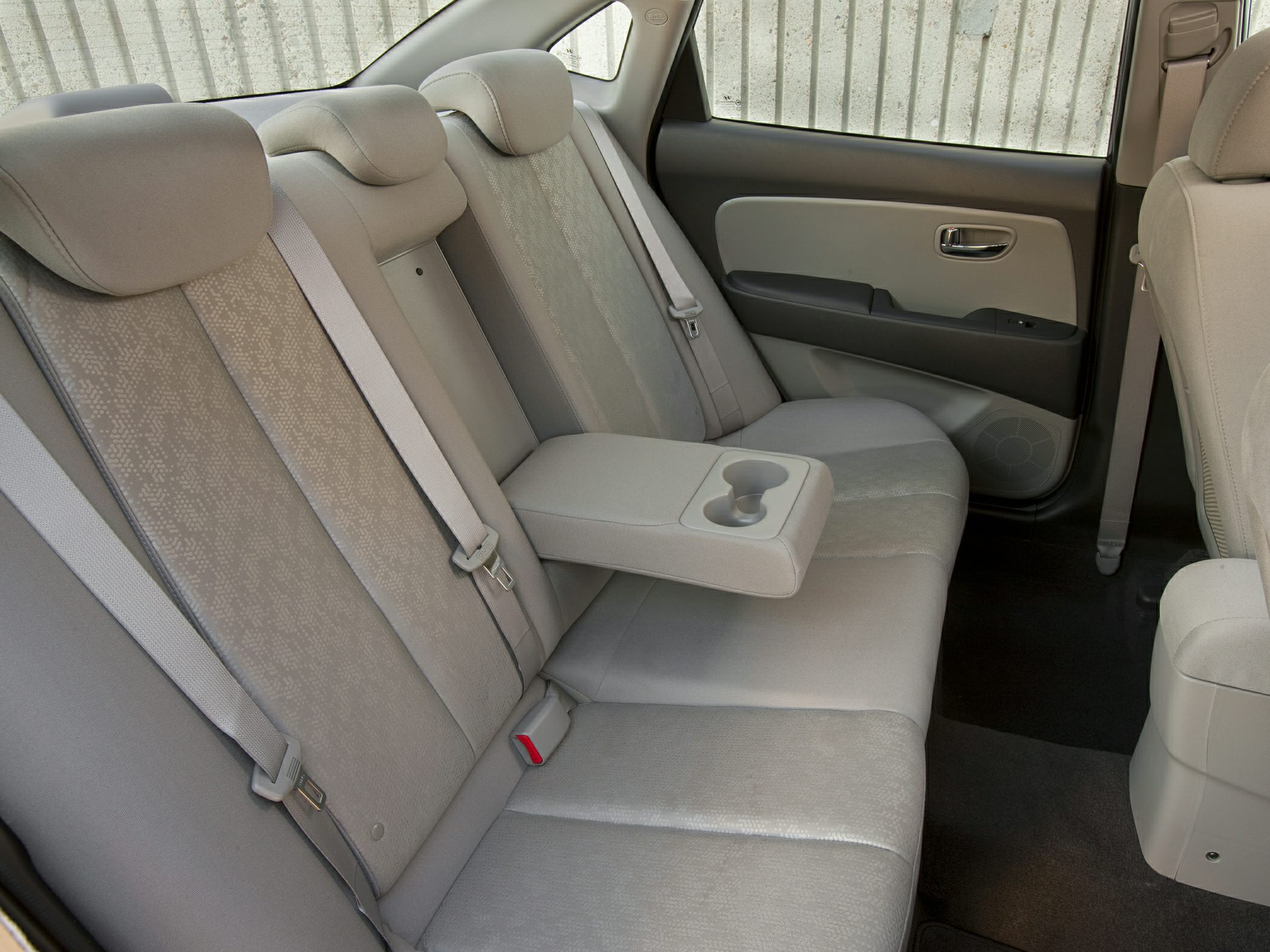 Beige rear seat with fabric upholstery and fold-down armrest cup holder