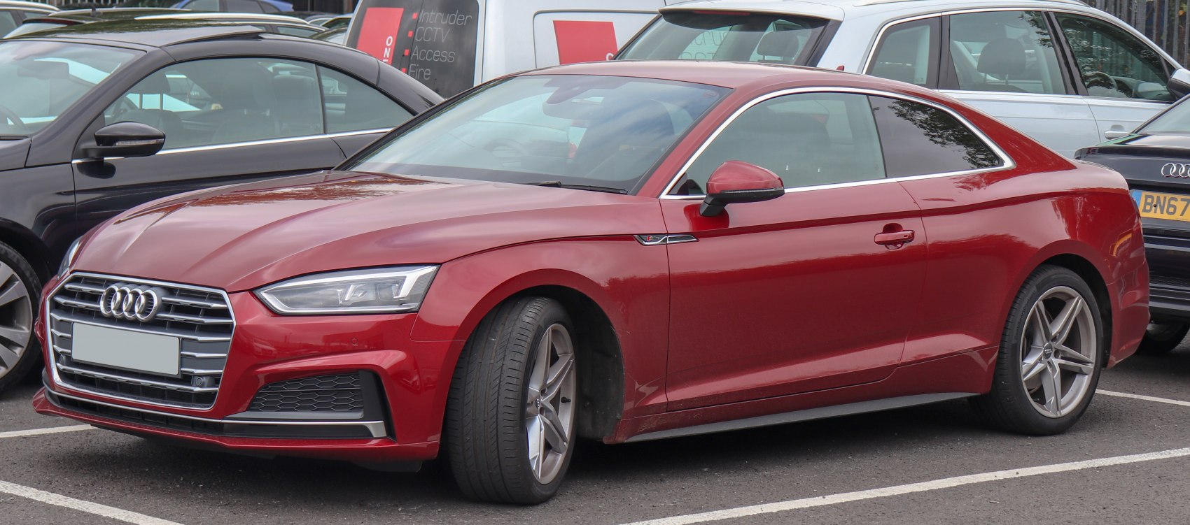 Red sporty coupe with sharp headlights and alloy wheels