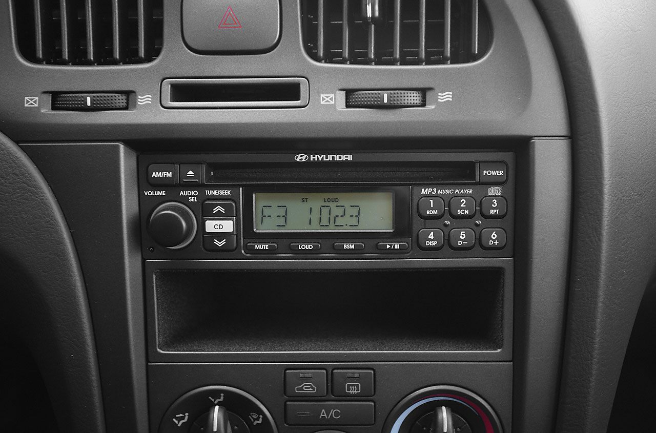 Close-up of car radio and climate control panel with buttons and knobs