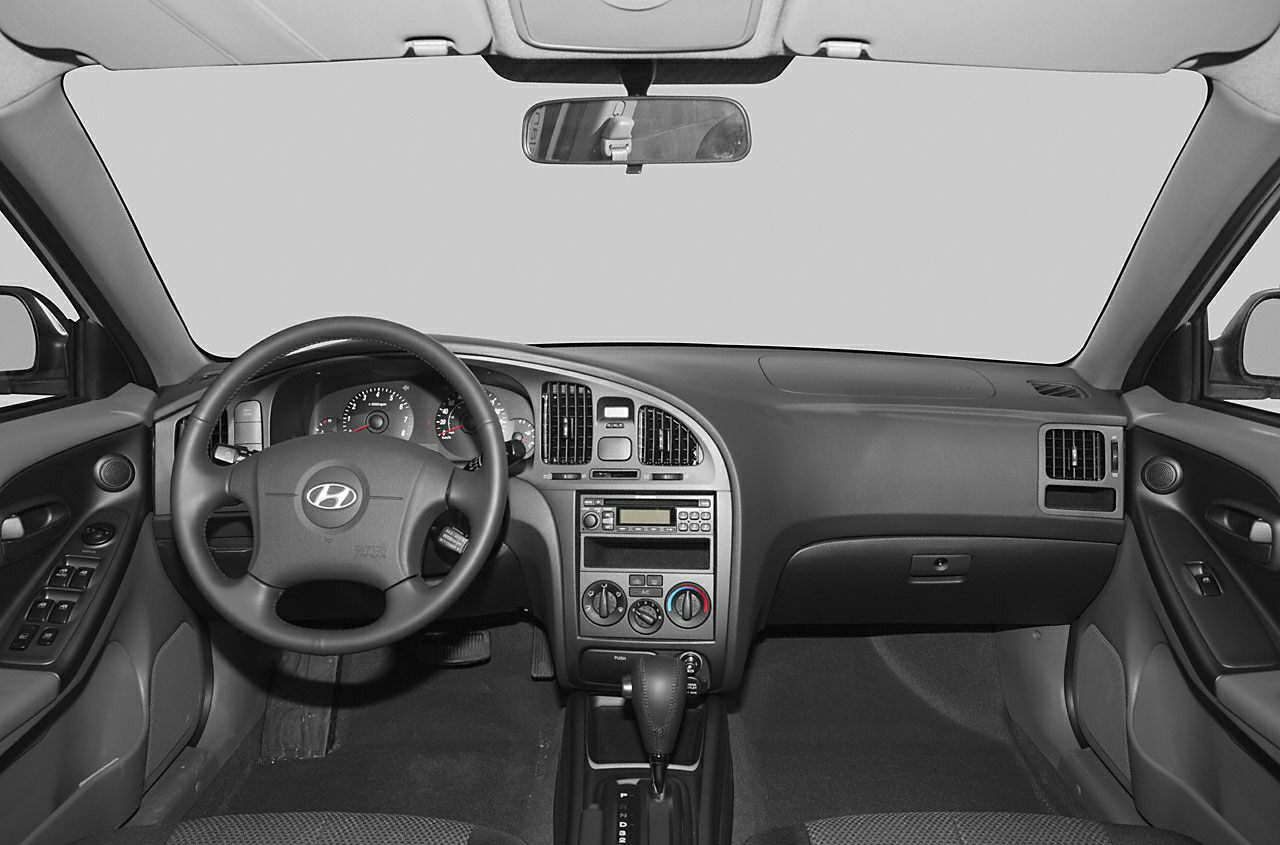 Dashboard and steering wheel with analog gauges, central controls.