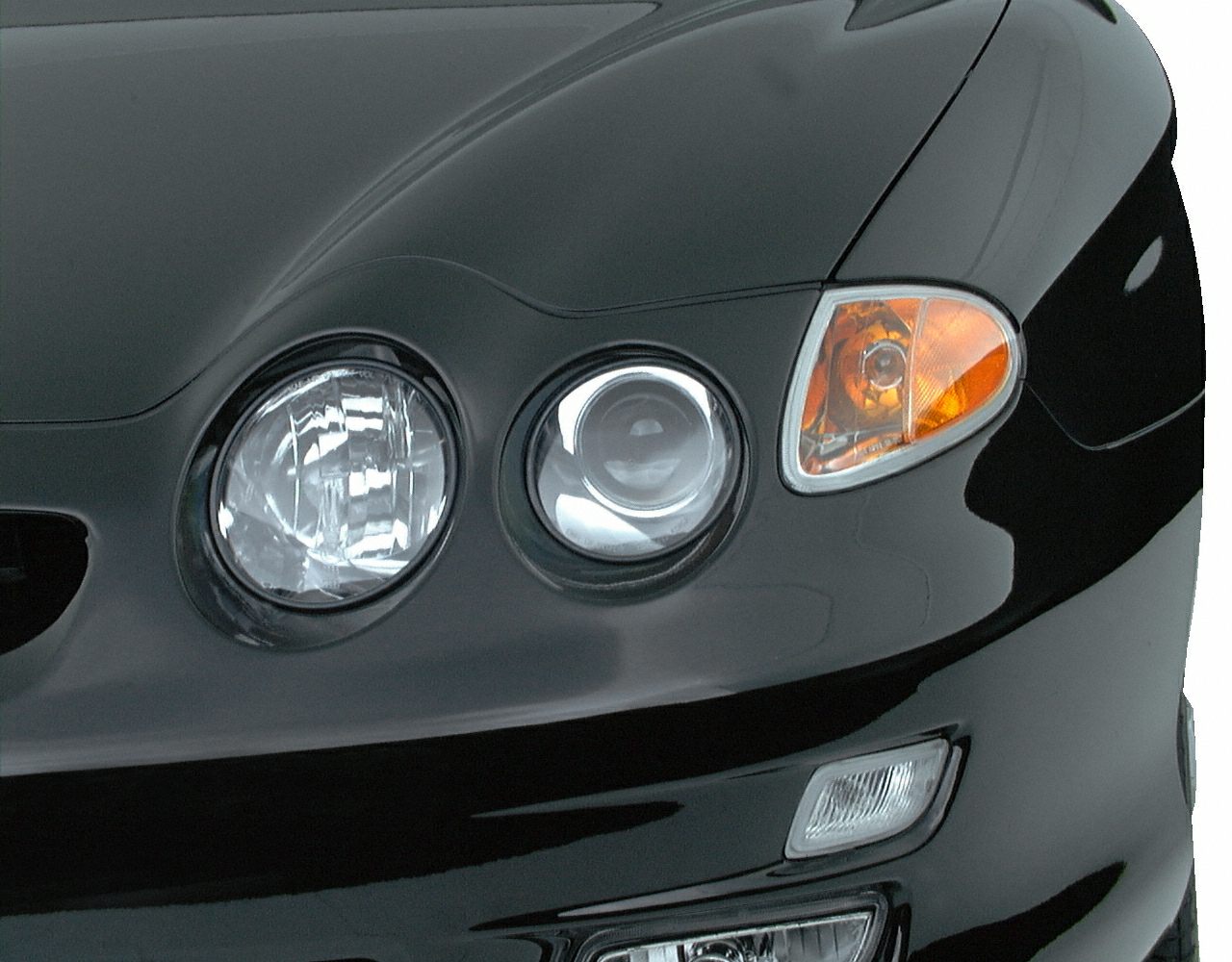 Dual round headlights with amber indicator and fog light on black surface