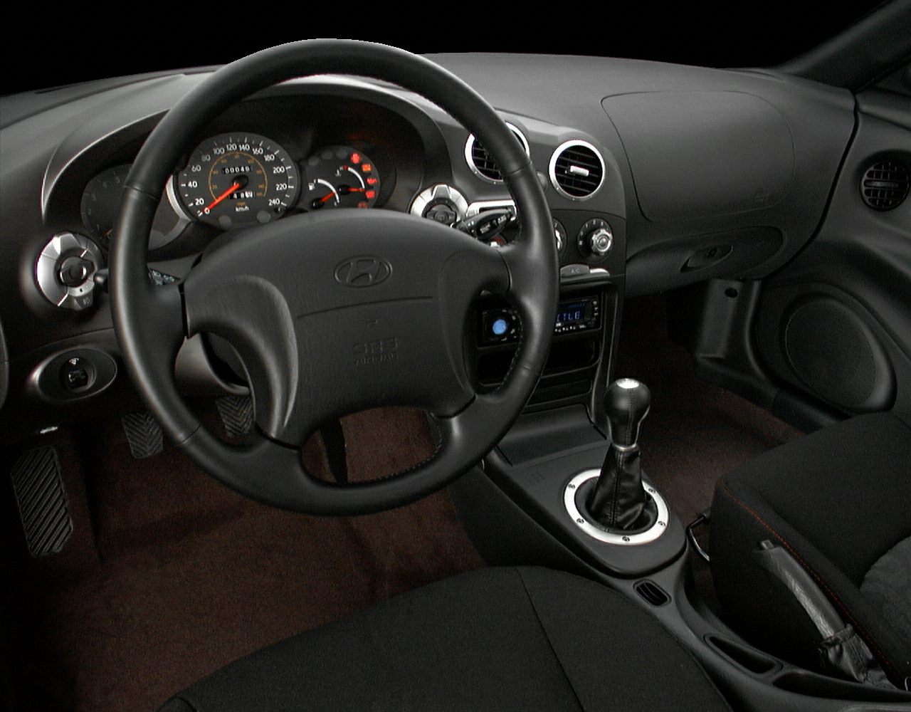 Car interior with dashboard, steering wheel, and manual gear shift