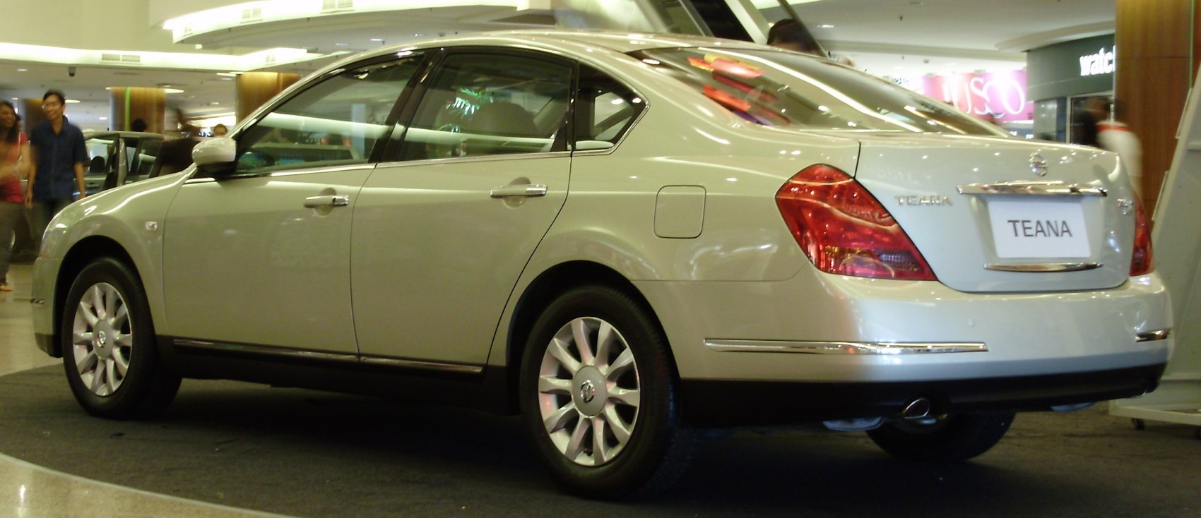 Rear side view of a four-door sedan with distinctive tail lights and alloy wheels