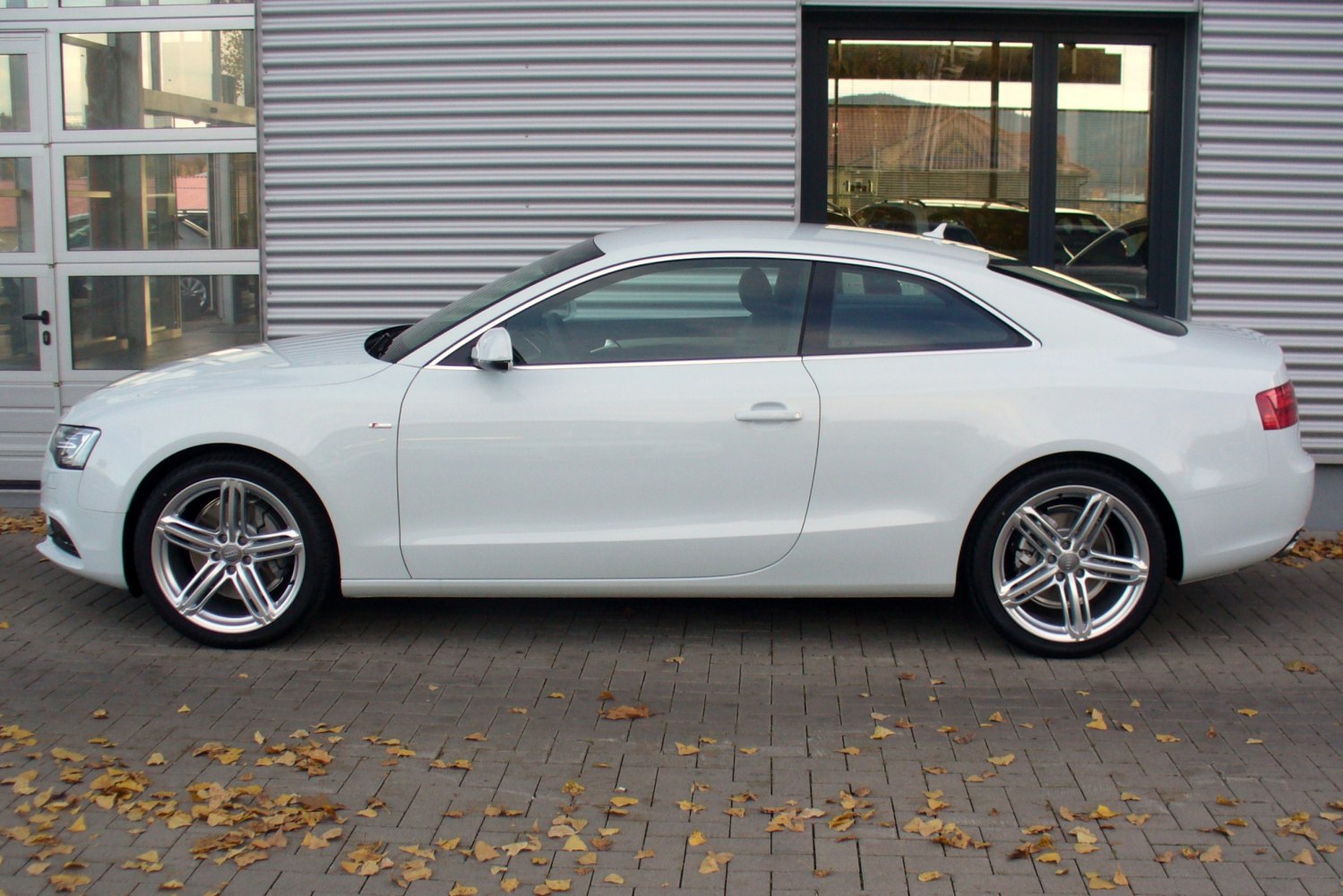 White coupe side profile with alloy wheels and smooth aerodynamic lines
