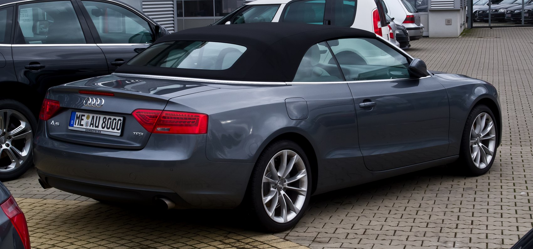 Rear side view of convertible with soft top and alloy wheels