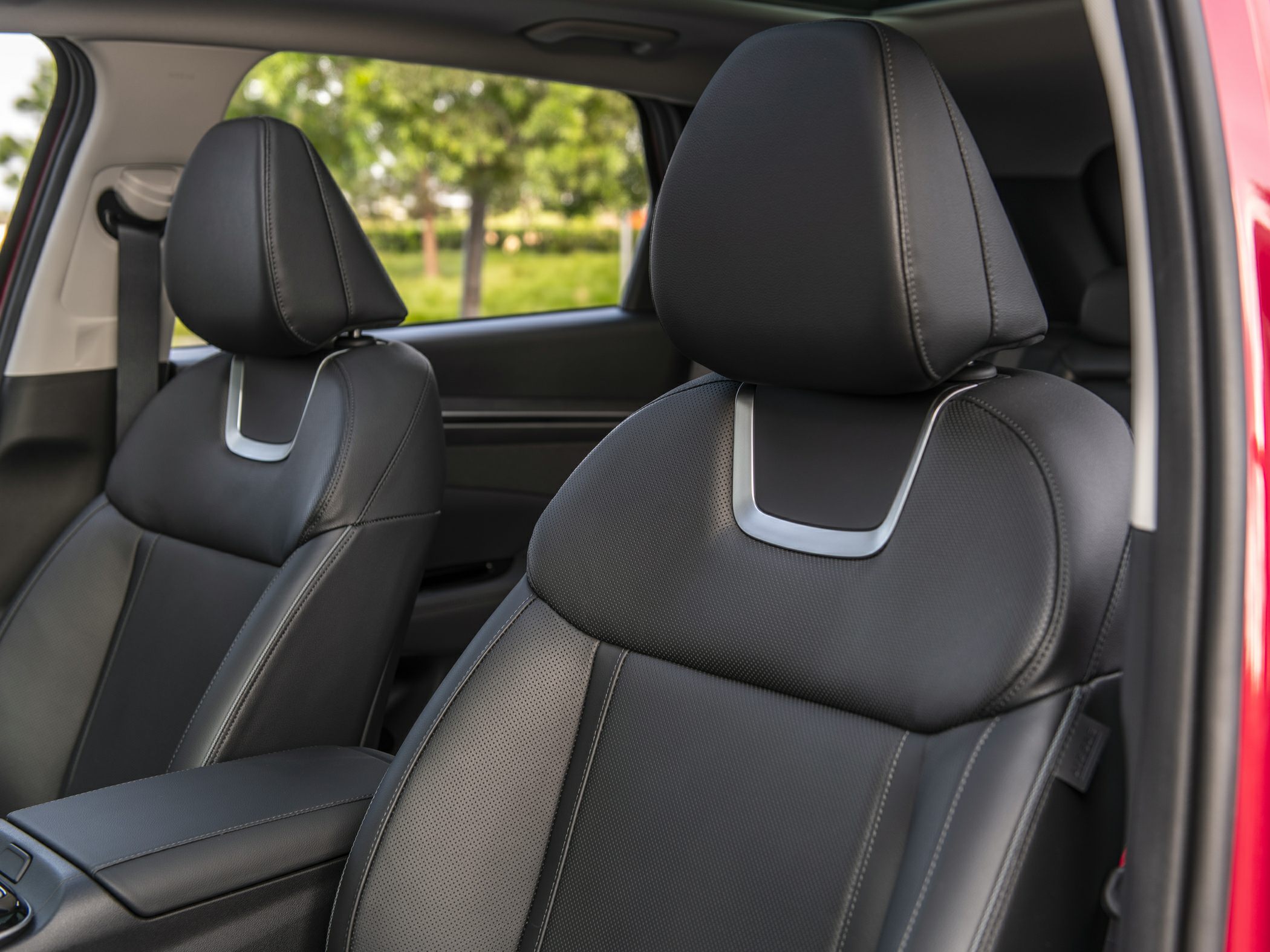 Close-up of leather front seats with headrests and armrest.