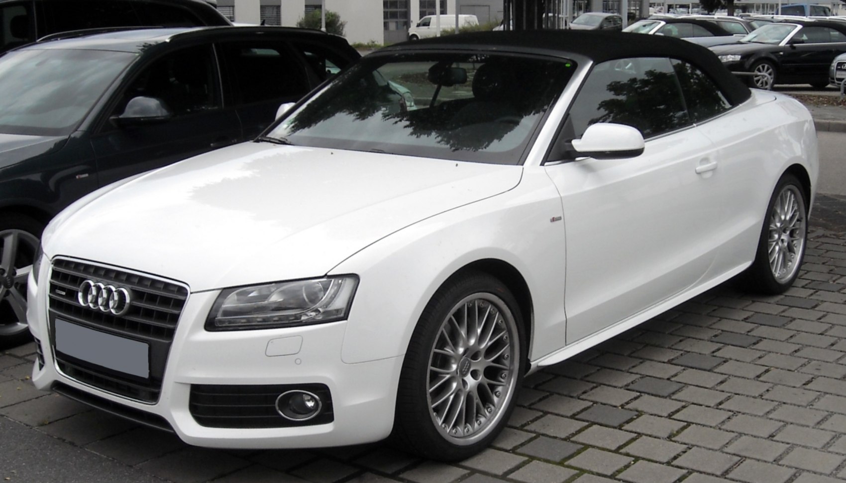 Front three-quarter view of a convertible with soft top and alloy wheels