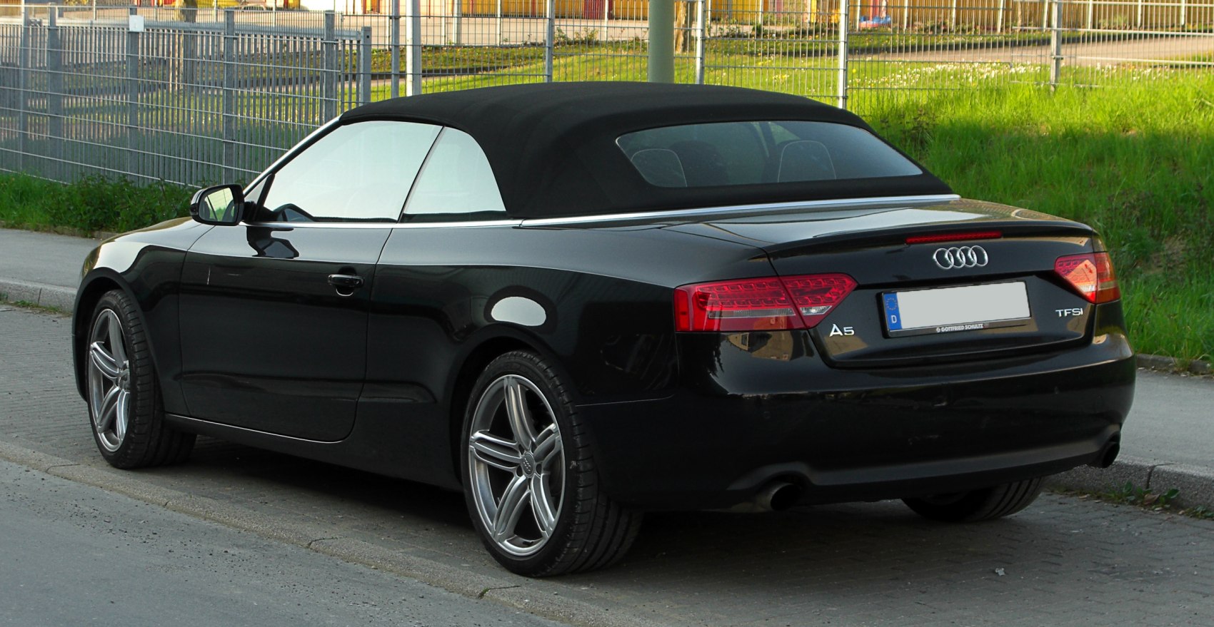 Rear view of black convertible with soft top roof and distinctive taillights