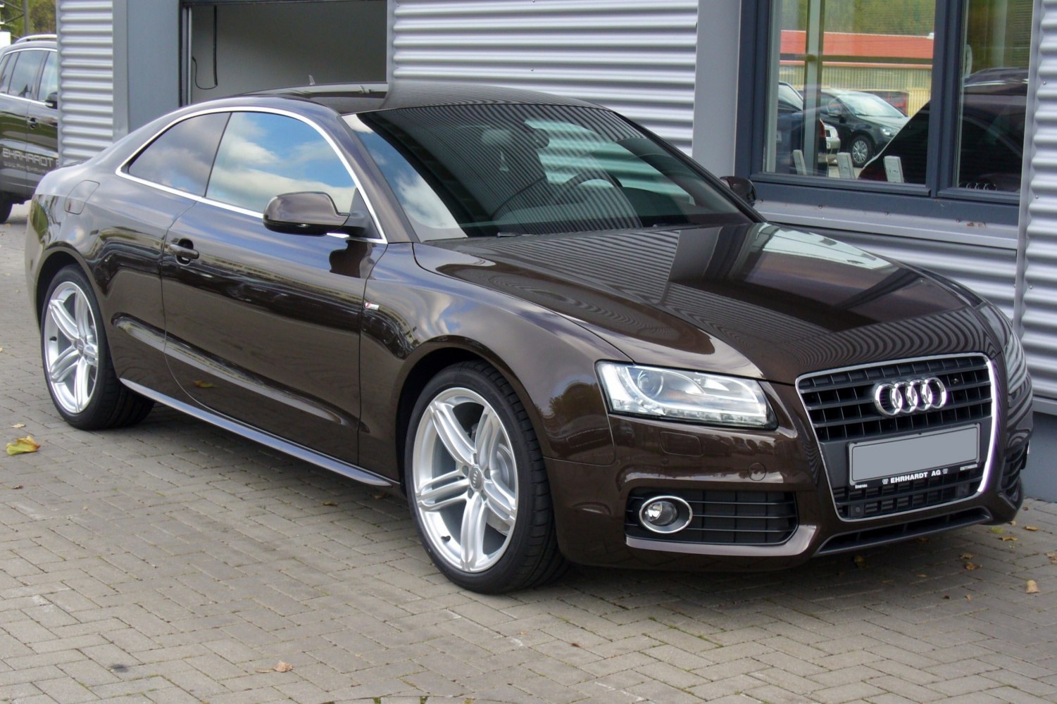 Front side profile with grille, headlights, and alloy wheels