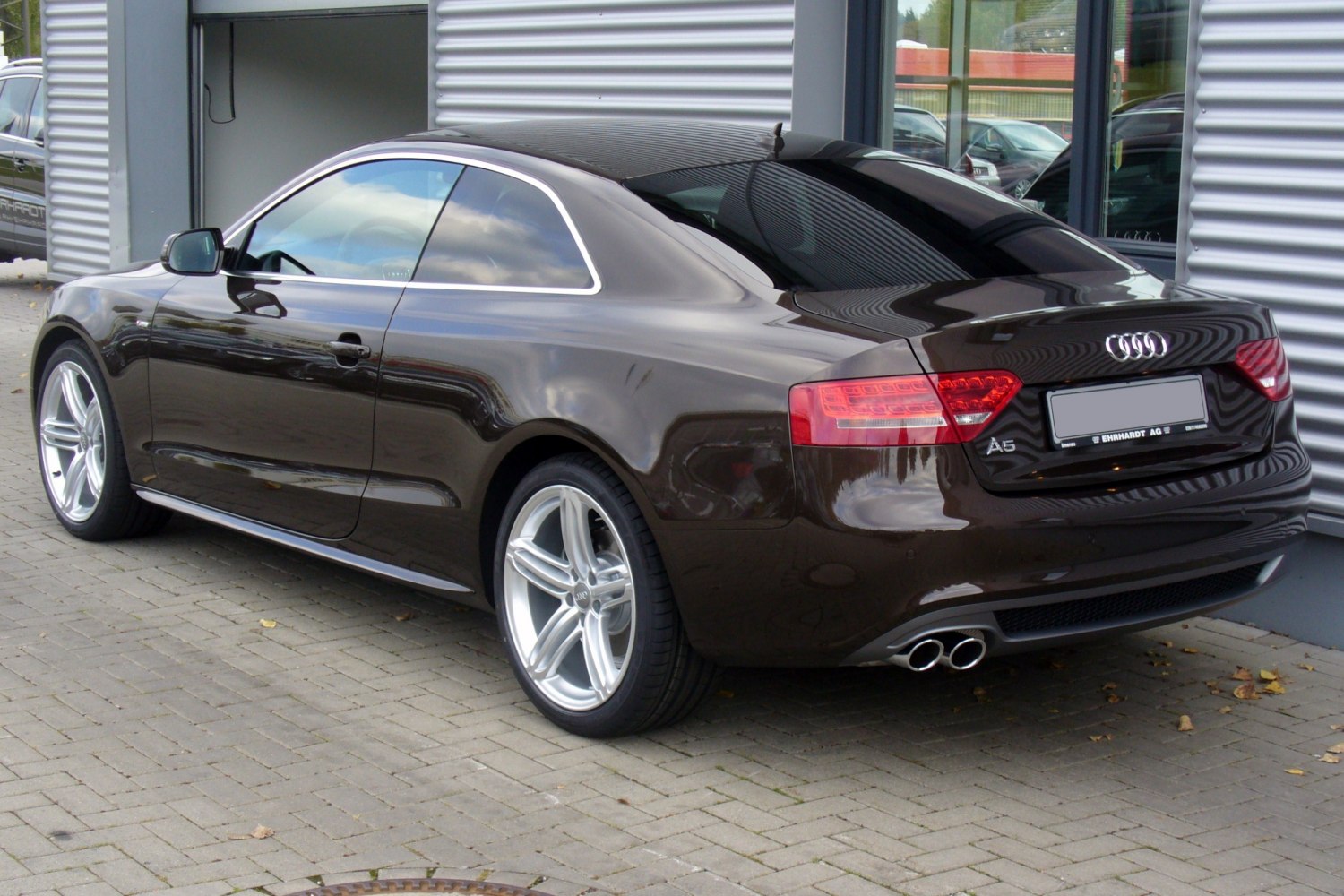 Rear side view of coupe with dual exhaust and alloy wheels