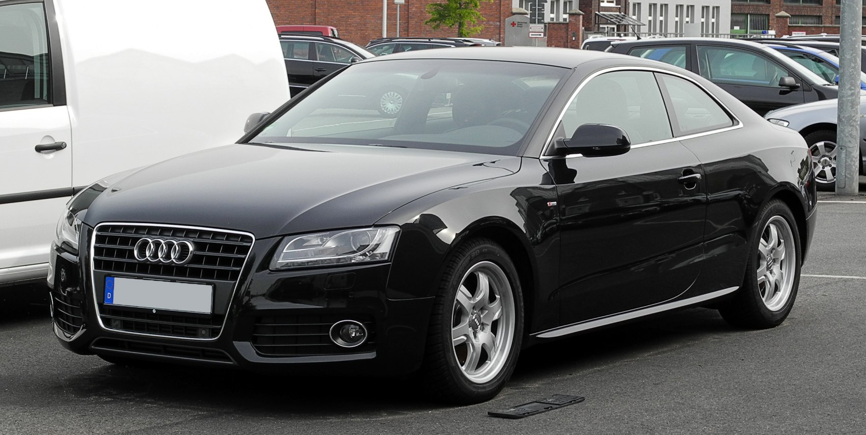 Front side view of a black luxury coupe with distinct Audi grille and alloy wheels