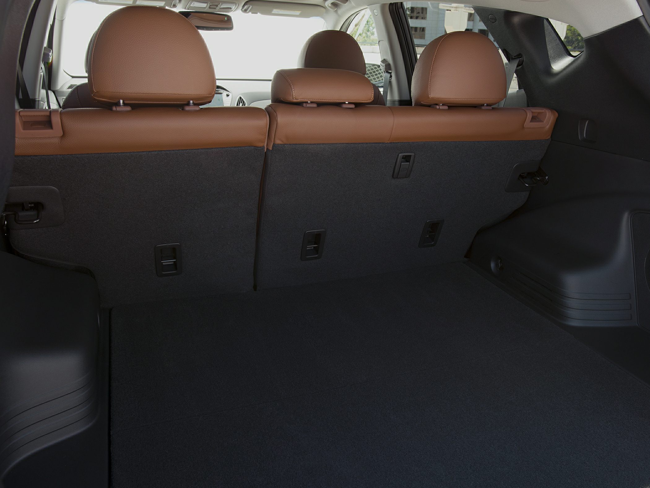 Rear cargo area with brown leather split-folding seats and black floor covering