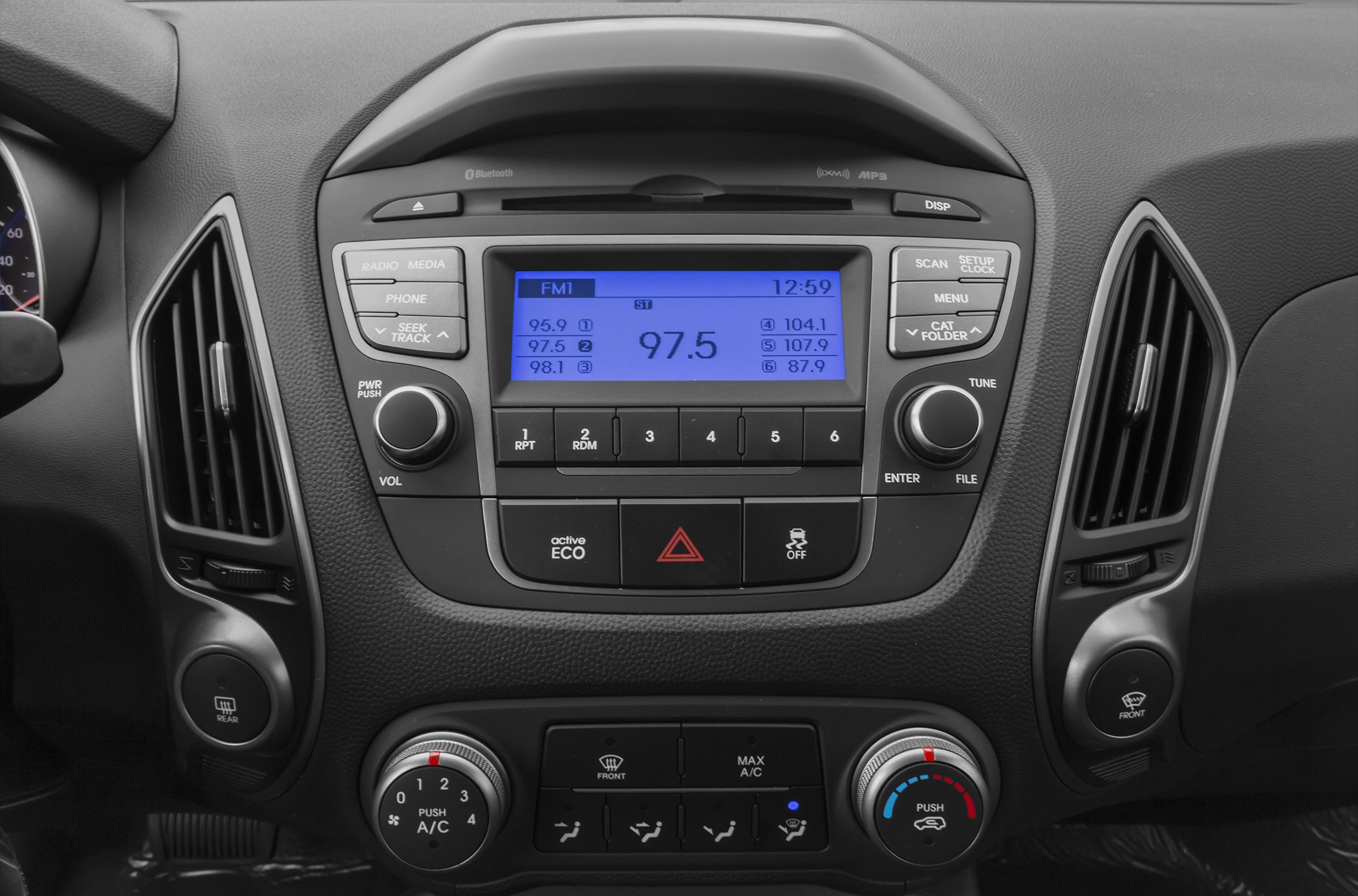 Car radio and climate control panel with digital display and buttons.