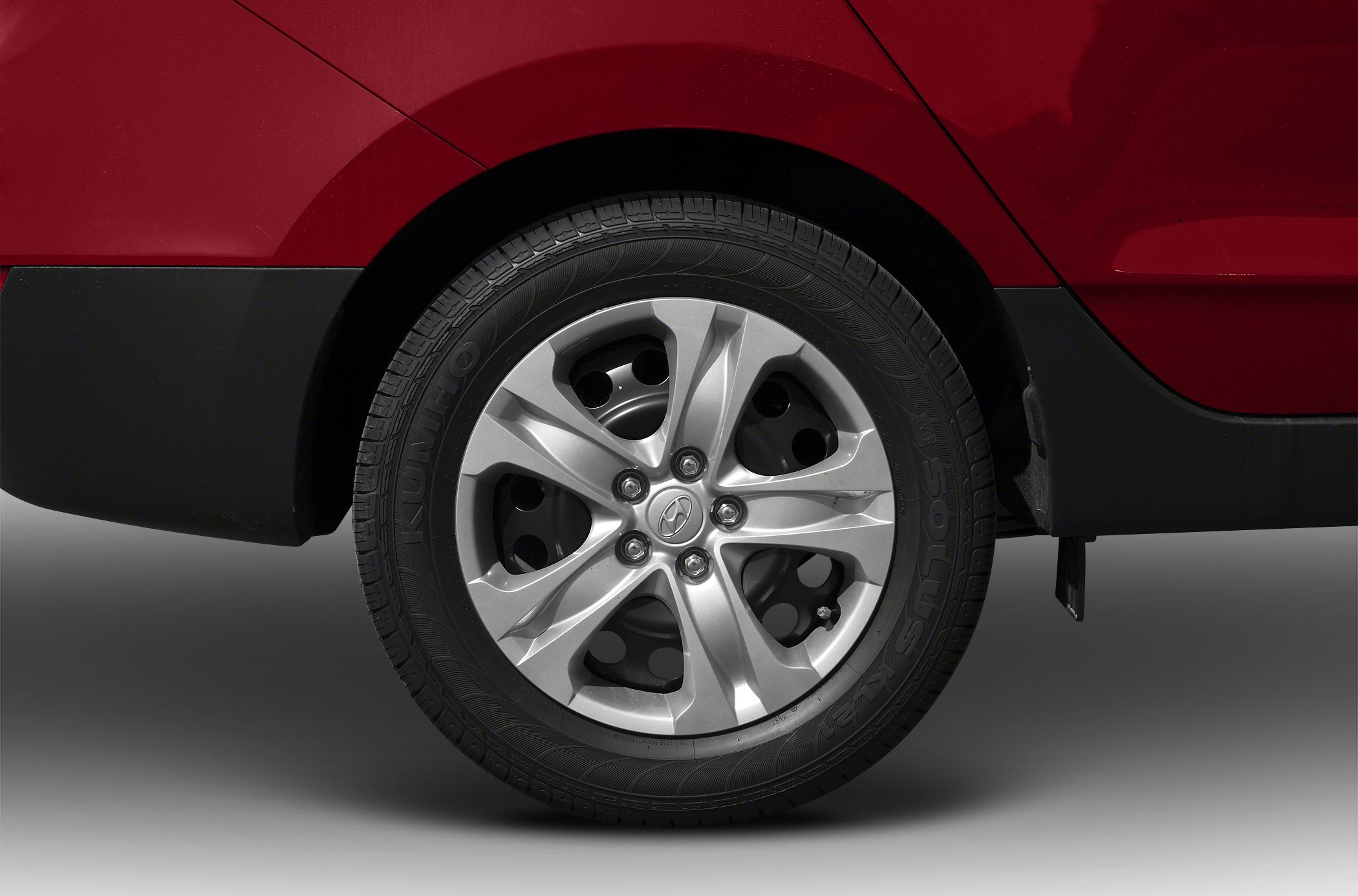Close-up of alloy wheel and tire with distinct rim design and tire tread.