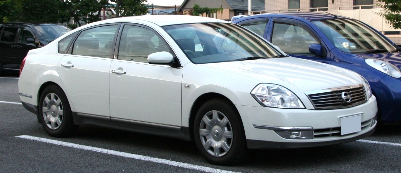 Front grille and side profile of a white mid-2000s sedan