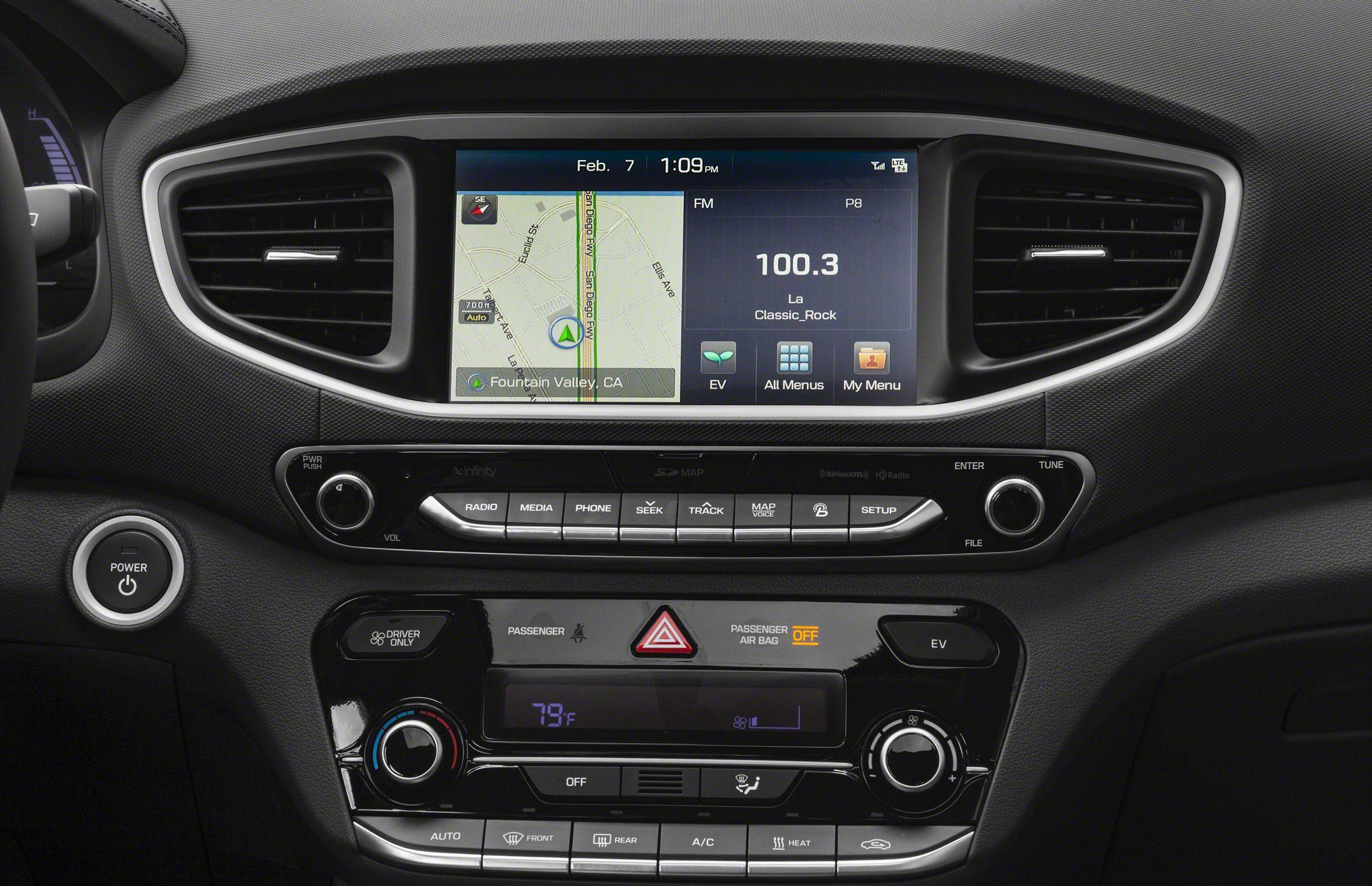 Car dashboard with touchscreen infotainment, climate and media controls, and EV mode button