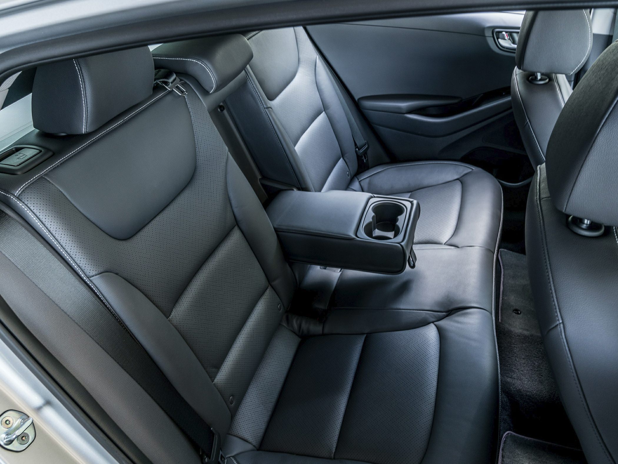 Black leather rear seats with fold-down armrest and cup holder.