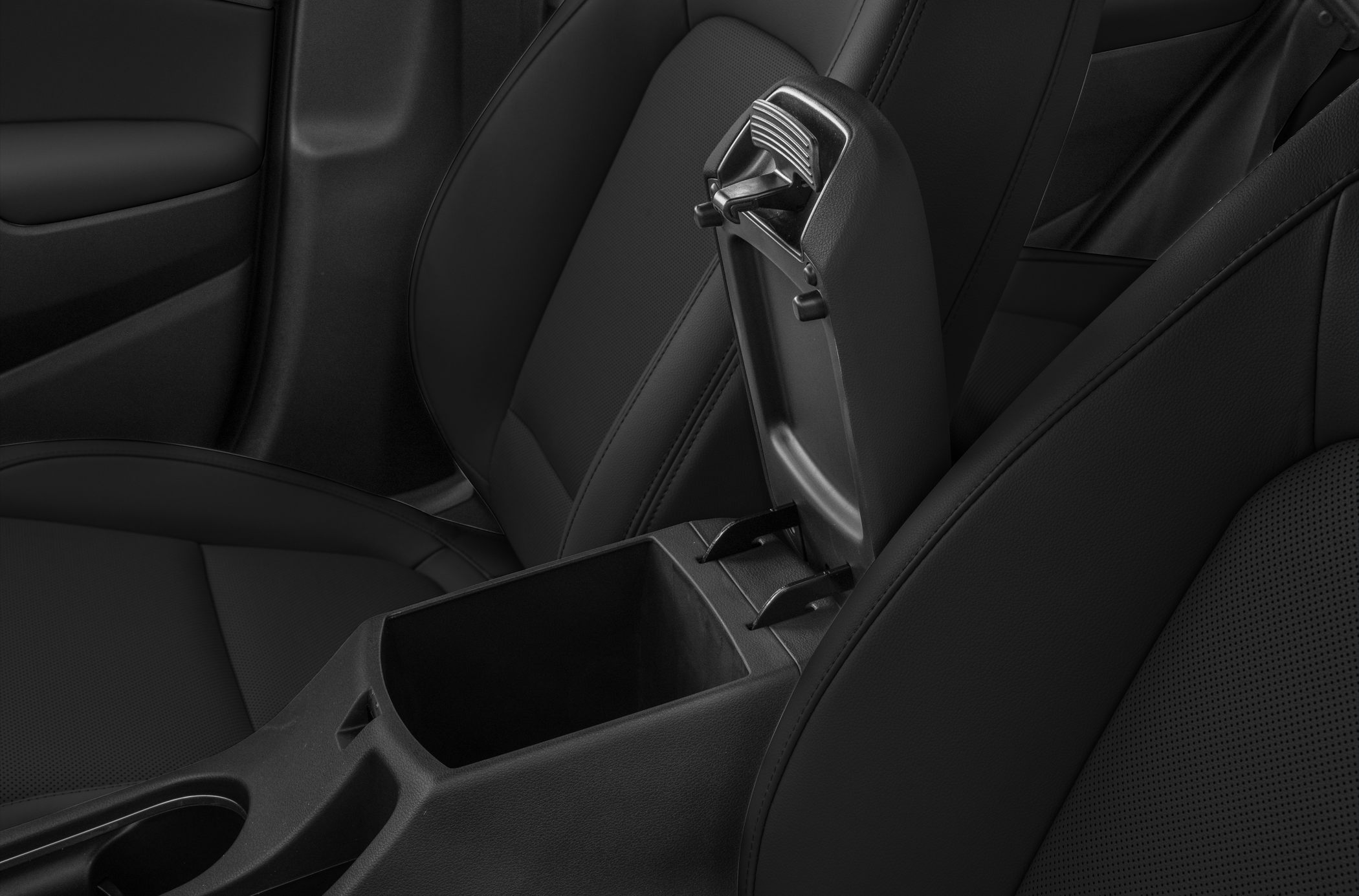 Open car center console storage with black leather seats