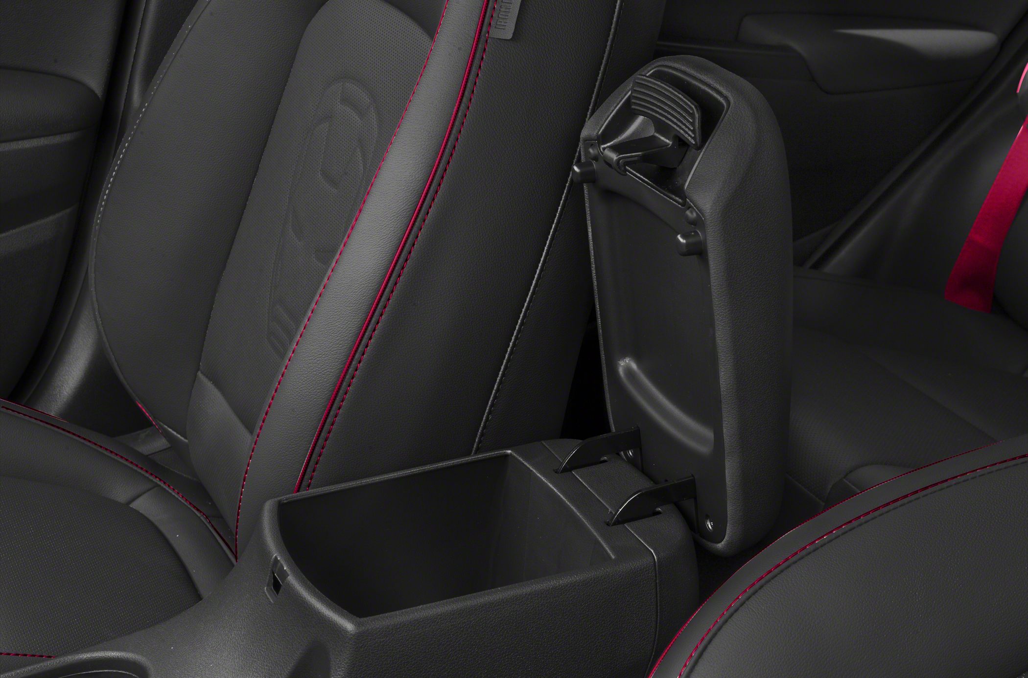 Open center console storage with black leather seats and red stitching