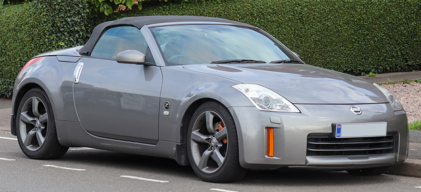 Front side view of a gray convertible with alloy wheels and soft top