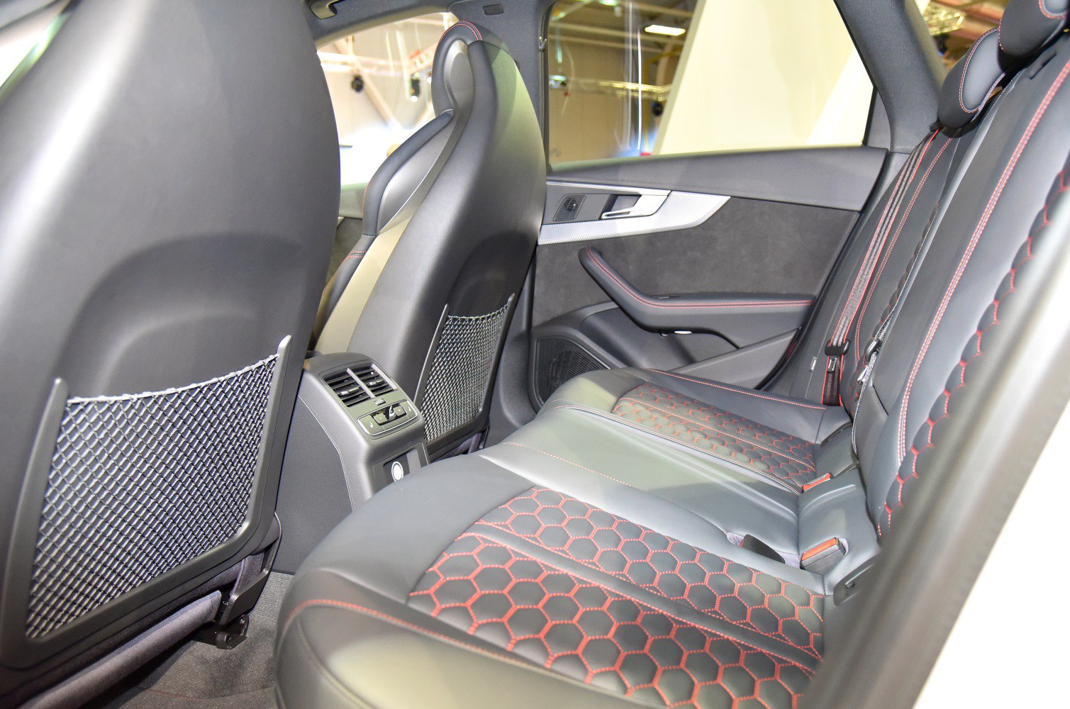 Black leather rear seats with red hexagonal stitching and rear air vents
