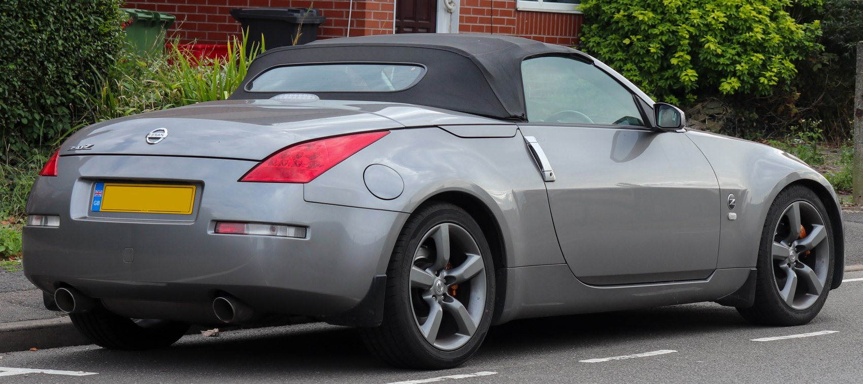Rear and side view of a soft top convertible with distinctive taillights and alloy wheels.