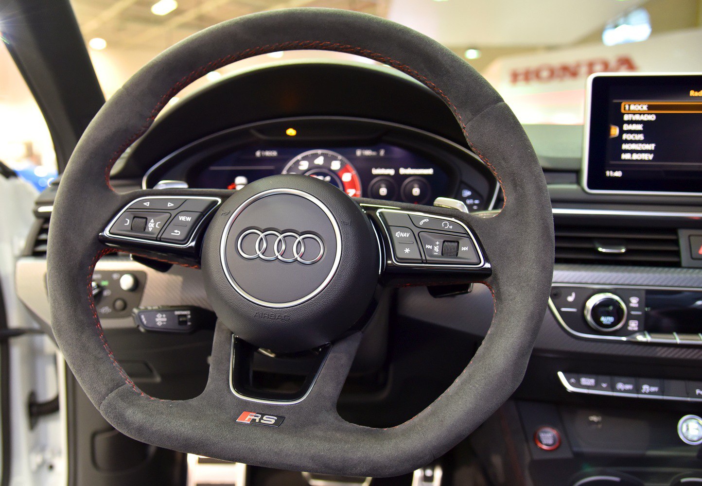Alcantara steering wheel with control buttons and digital dashboard display