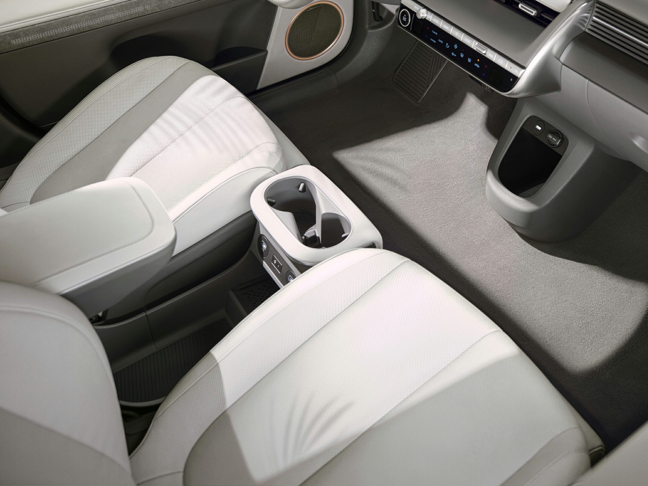 White front seats and minimalist center console in a spacious car interior