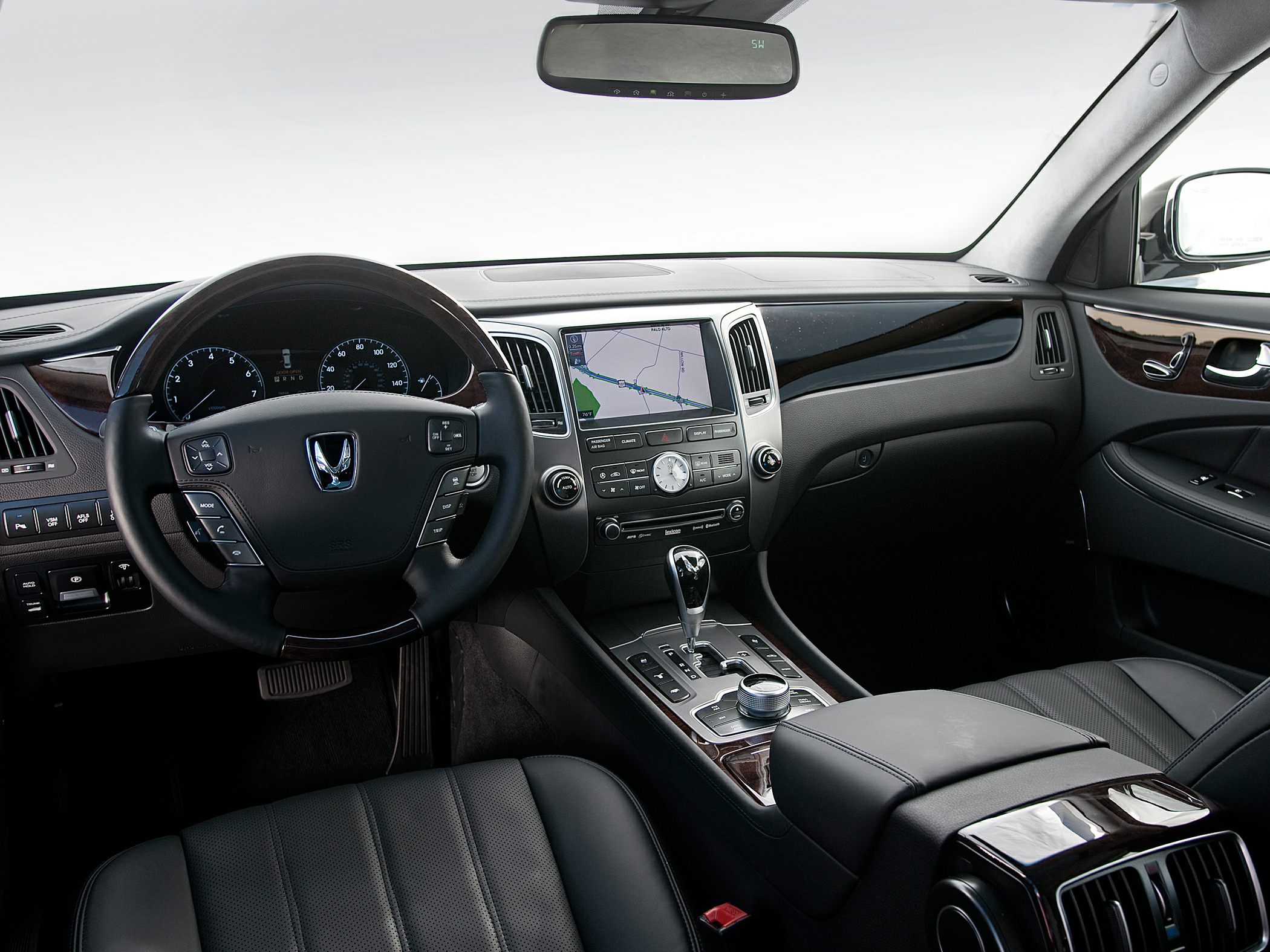 Luxury car interior with touchscreen, wood trim, leather seats, and multifunction steering wheel