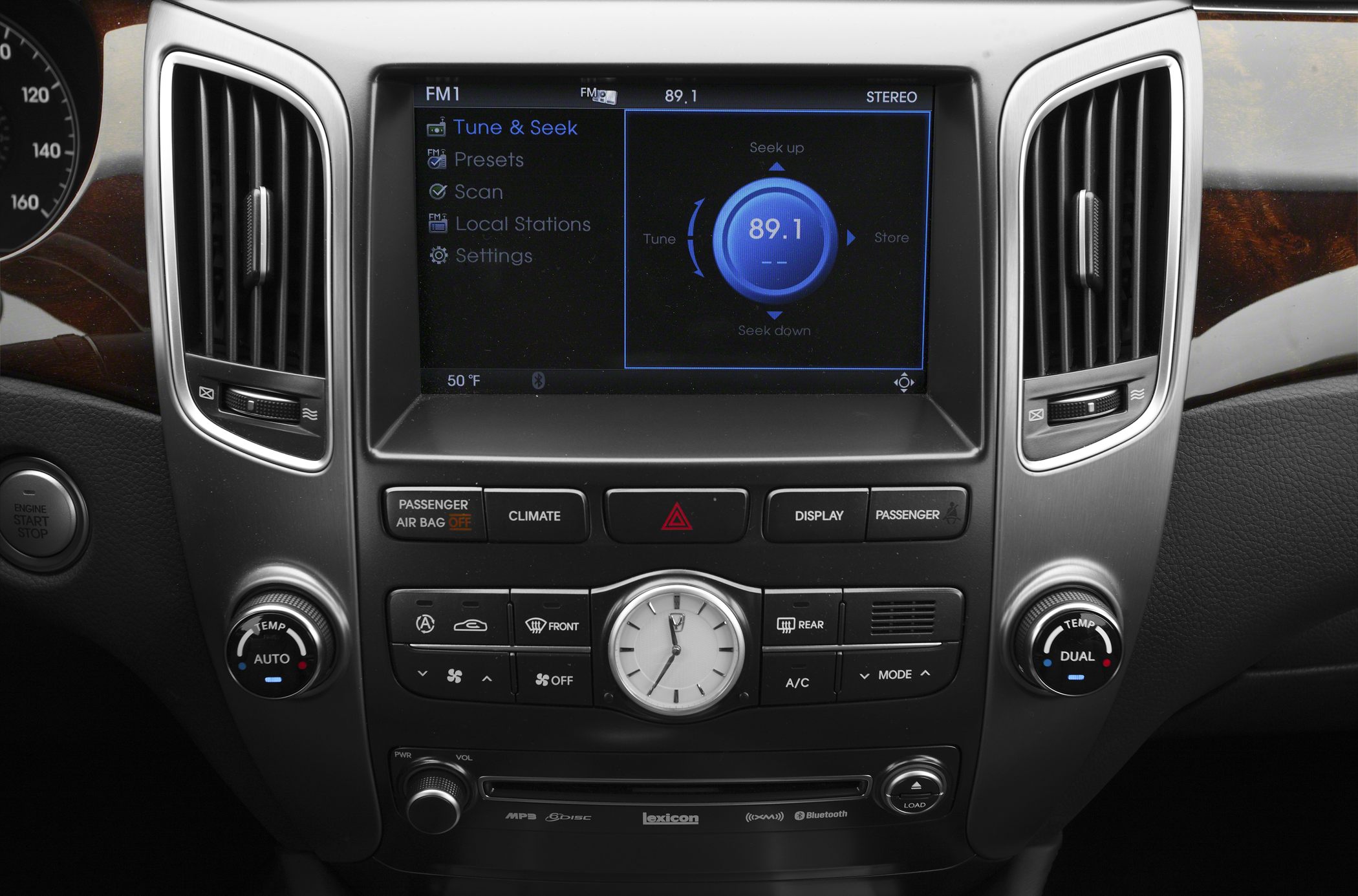 Multimedia touchscreen and dashboard control panel with air vents and analog clock