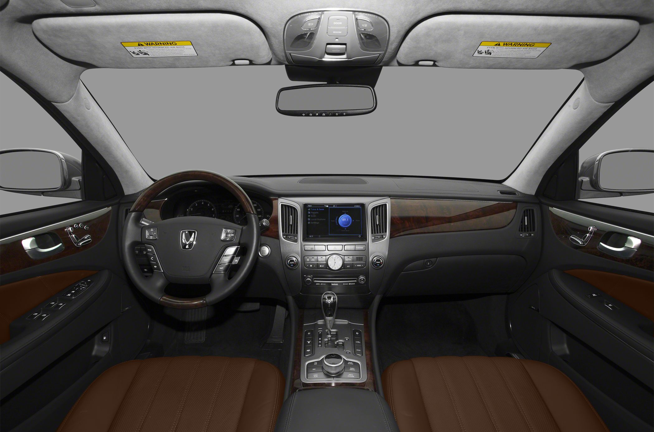 Luxury sedan interior with leather steering wheel, wood trim, and infotainment display