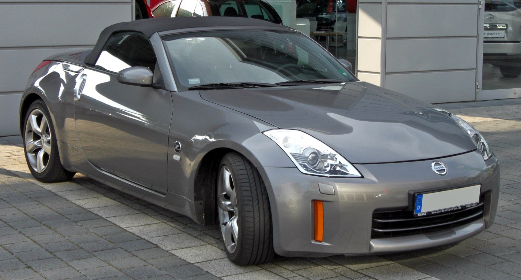 Gray soft-top convertible roadster with sleek aerodynamic body and alloy wheels