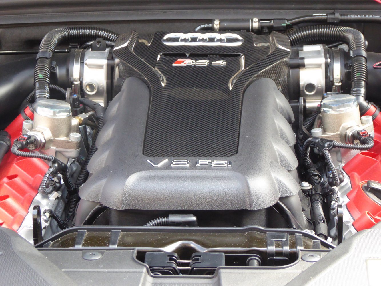 Close-up of V8 FSI engine with carbon fiber cover and mechanical details