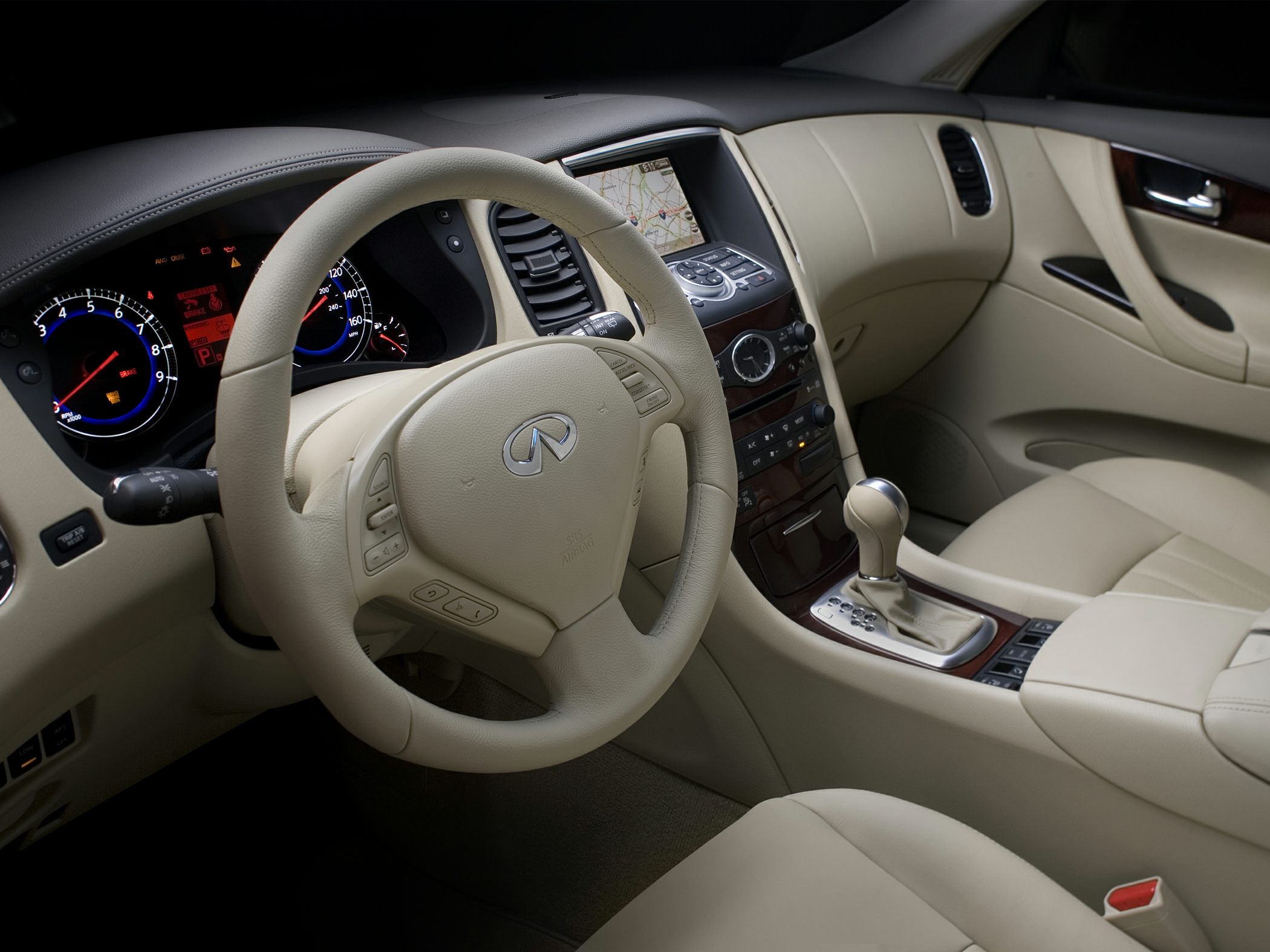Beige leather steering wheel and advanced dashboard with navigation.