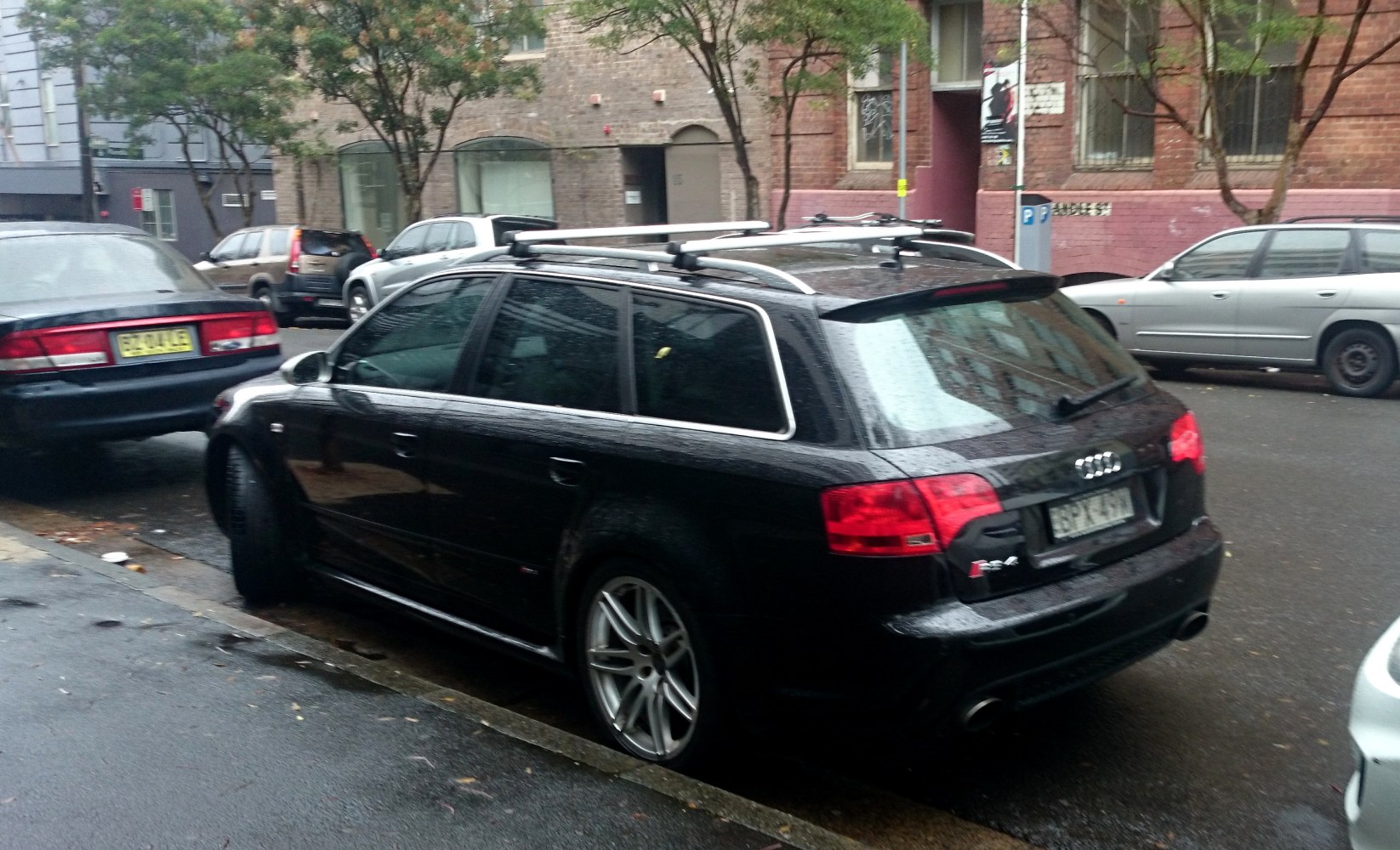Rear side view of black wagon with roof rails and dual exhaust